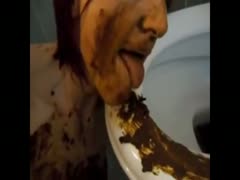 Red-haired whore cleans shit on a toilet bowl using her tongue